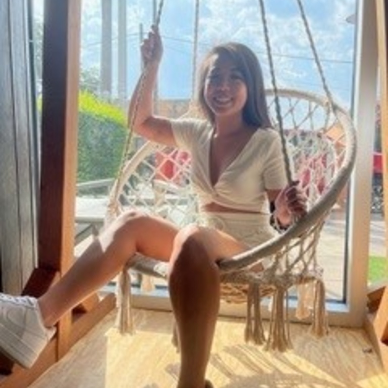 Janel sitting on a swing smiling into the camera