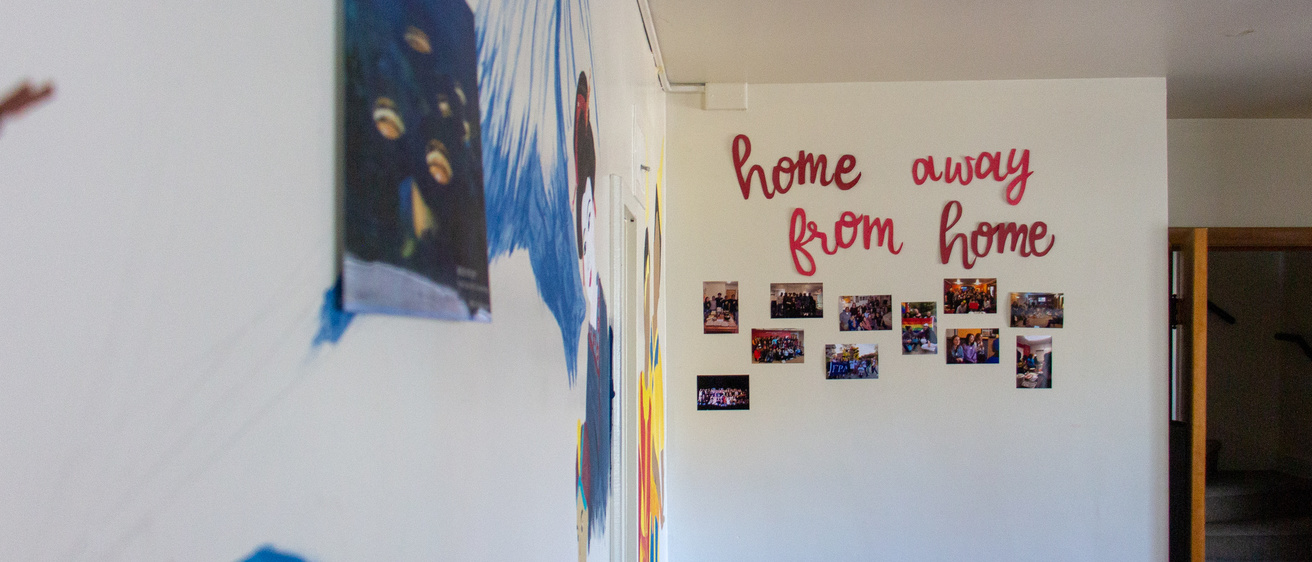 The kitchen of the APACC. Paintaings cover the walls and words read, "home away from home"