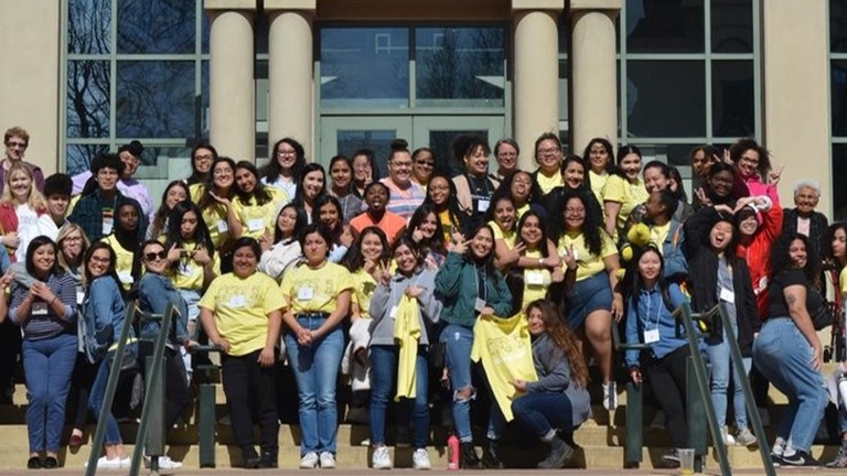 Large group of students posing on the stairs of a university building